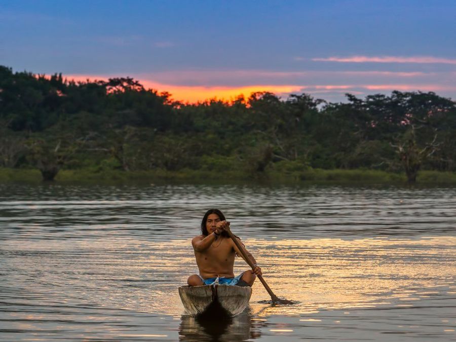 Foto de referencia: persona en canoa sobre una laguna amazónica al atardecer; no representa un evento real.